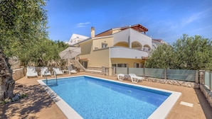 A two-story house with a swimming pool, outdoor seating, and a stone wall. - Cozy home in Trogir with private swimming pool, can be inside or outside (Trogir)