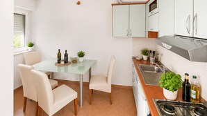 Uma cozinha moderna com mesa de jantar, cadeiras e fogão.