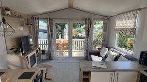 Un espacio habitable compacto con kitchenette, comedor y zona de estar con vistas al exterior.