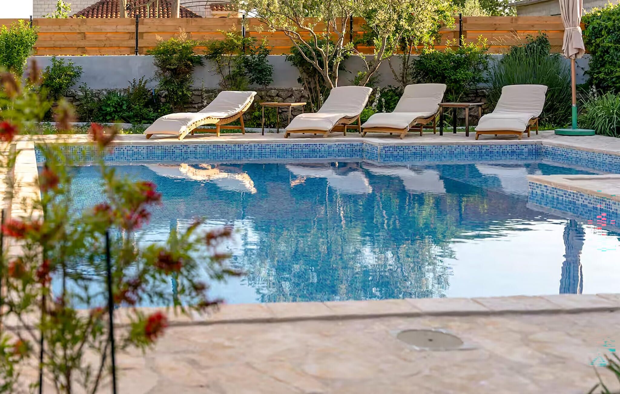 A swimming pool with lounge chairs and a stone deck.