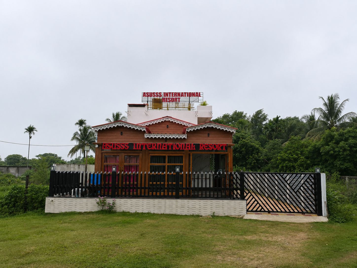 Un edificio de dos pisos con un letrero que dice 'Asuss International Resort'.