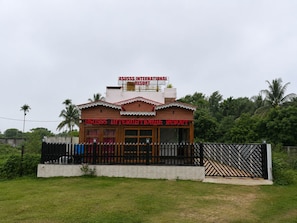A two-story building with a sign reading 'Asuss International Resort'.