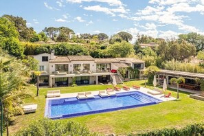 A modern house with a swimming pool, outdoor seating, and a garden. - Luxe: Villa Ocean Whisper 8BR/16P (Saint-Tropez)
