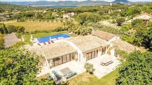 Una villa con piscina, mobiliario de exterior y vistas al mar y a las montañas.