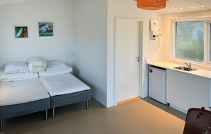 A compact room with a bed, a small kitchenette, and a window. - Beach front home in Samsø with house sea view (Samsø)