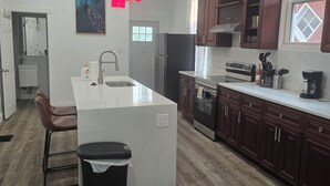 Una cocina moderna con una isla central, armarios de madera, un refrigerador y un ventanal con vistas.