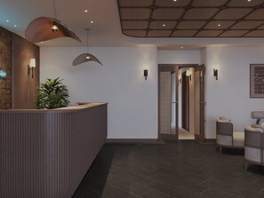 A reception area with a wooden reception desk, a potted plant, and a seating area with two chairs. - Harmony Boutique Cruise (Tuan Chau)