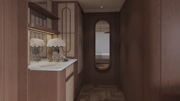 A hallway with a marble counter, a mirror, and a view into a bedroom.