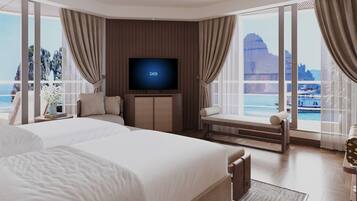 A modern hotel room with a large bed, a flat-screen TV, and a balcony with a view of the sea.