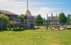 A playground with wooden structures, including a slide and climbing frames. - Awesome apartment in Ribnitz-Damgarten with WiFi (Ribnitz-Damgarten)