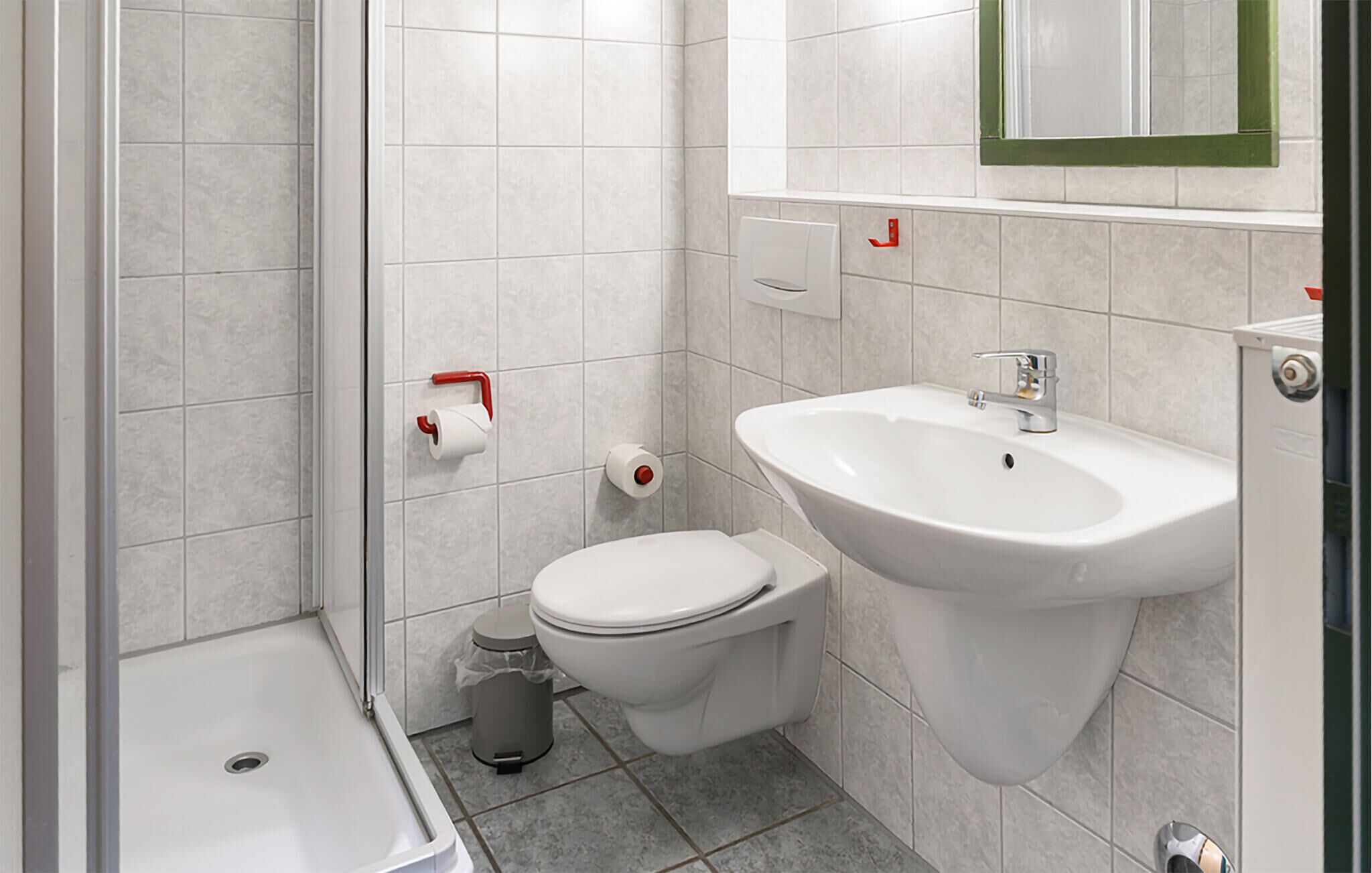 Une salle de bain avec douche, toilettes et lavabo.