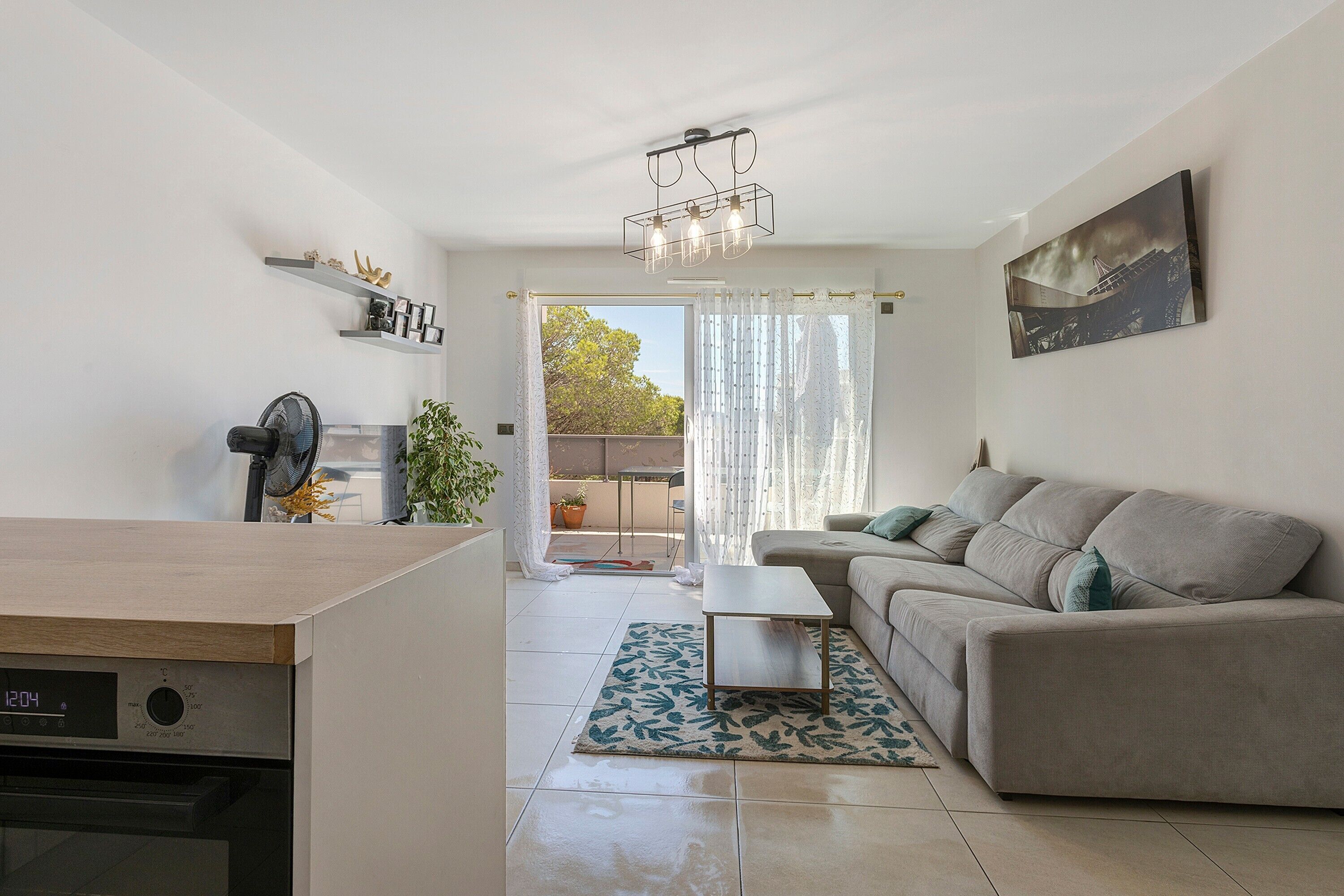 Een moderne woonkamer met een bank, een salontafel en een eethoek met een tafel en stoelen.