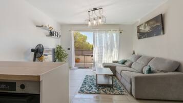 Een moderne woonkamer met een bank, een salontafel en een eethoek met een tafel en stoelen.