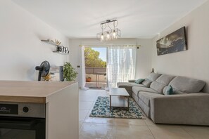 Un salon moderne comprenant un canapé, une table basse et un coin repas avec une table et des chaises.