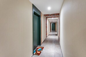 A corridor with a patterned carpet, a green door, and a tiled floor. - Apartment 'Charmant Deux Pieces Fréjus Proche' with Wi-Fi (Fréjus)