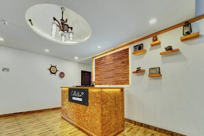 Un área de recepción con un mostrador de madera, un reloj en la pared y un panel de madera en la pared.
