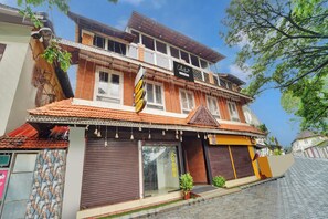 A two-story building with a traditional architectural style, featuring a balcony and a sign indicating a restaurant. - Collection O Calvathy Road Near Fort (Kochi)