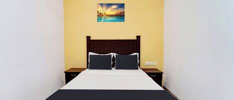 A hotel room with a bed, two bedside tables, a nightstand, and a painting on the wall.
