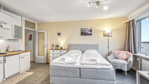 A hotel room with a bed, bedside table, chair, and a view of the outdoors. - Stunning apartment in Schleswig with WiFi (Schleswig)