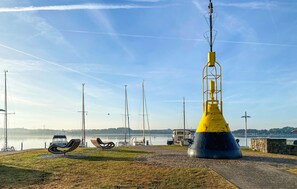 A coastal area with a prominent yellow and blue structure, possibly a lighthouse or marker, near a body of water. - Stunning apartment in Schleswig with WiFi (Schleswig)