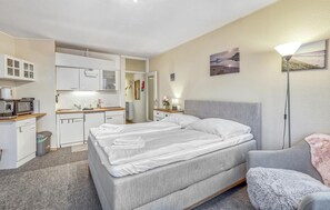 A compact hotel room with a bed, a chair, a desk, and a kitchenette. - Stunning apartment in Schleswig with WiFi (Schleswig)