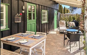 An outdoor patio with a table set for dining, a chair, and a sun lounger. - Beautiful apartment in Humlebæk with WiFi (Humlebæk)