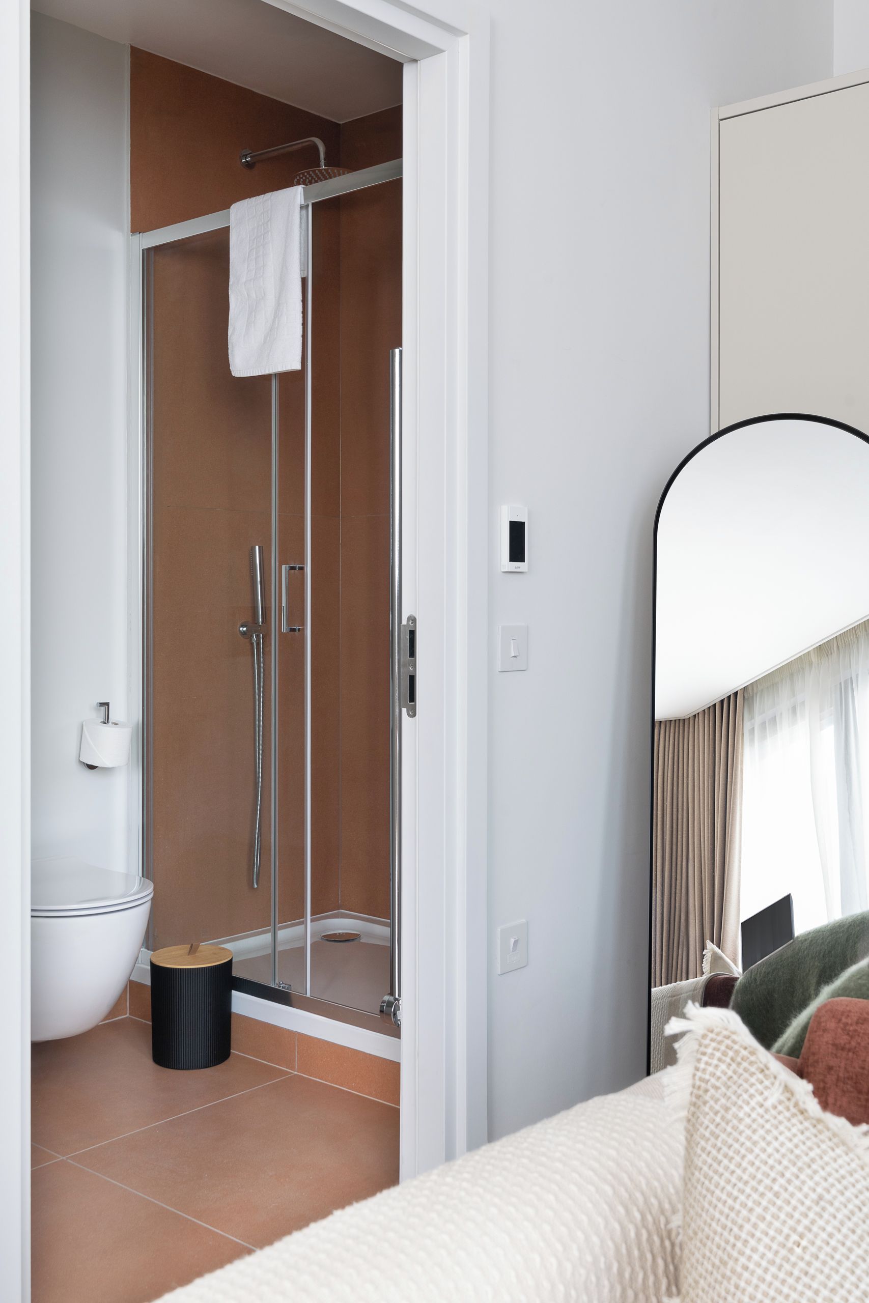 A modern bathroom with a glass-enclosed shower, a toilet, and a bidet.