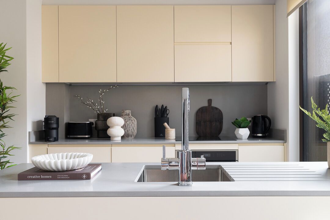 Una cocina moderna con un grifo elegante, un bol en la encimera y diversos utensilios de cocina.