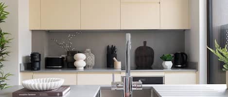 A modern kitchen with a sleek faucet, a bowl on the counter, and various kitchen items.