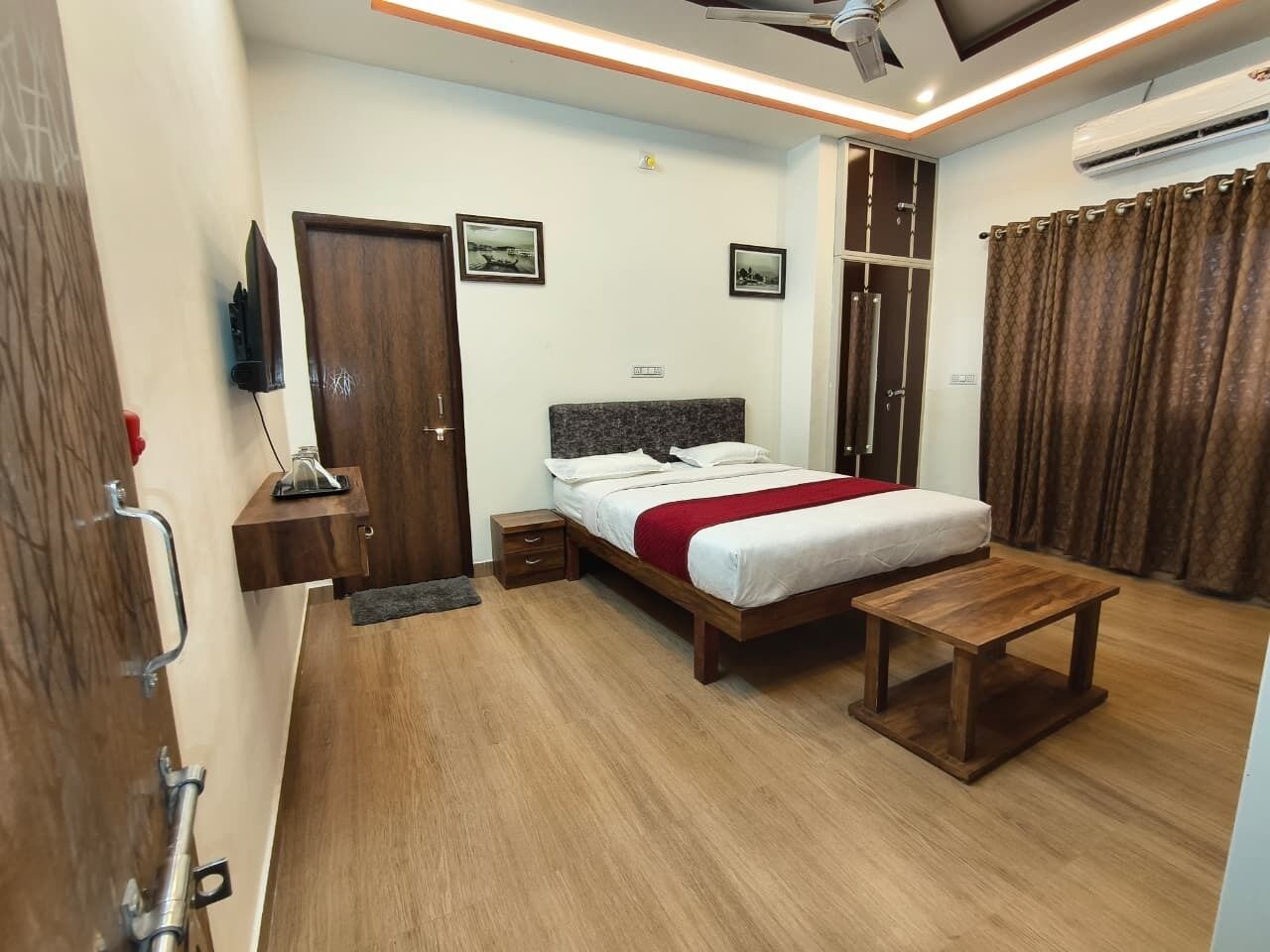 Quarto com uma cama, mesa de cabeceira e uma pequena mesa de madeira.