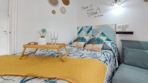 Un dormitorio ordenado con cama, mesita de noche y una decoración en la pared.