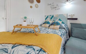 A neatly arranged bedroom with a bed, bedside table, and a wall decoration. - Pet friendly apartment in Benalmadena with swimming pool (Benalmadena)