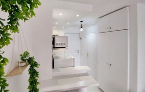 A modern interior with a staircase leading to a room, a white wardrobe, and a ceiling light fixture. - Pet friendly apartment in Benalmadena with swimming pool (Benalmadena)