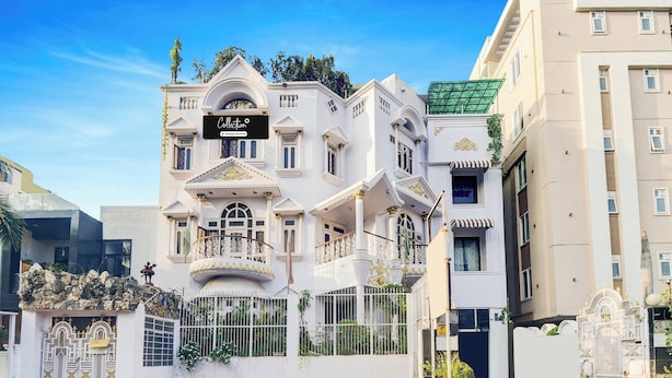 A multi-story building with a white facade, ornate balconies, and a gated entrance. - Collection O Raja Park Jaipur (Jaipur)