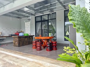 A modern kitchen with a central island, a dining table, and a large window.
