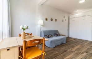 Ein gemütlicher Raum mit Esstisch, einer Couch und einem Bett.