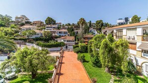 A residential area with a paved pathway leading through a garden, surrounded by houses with varied architecture. - Gorgeous apartment in Málaga with swimming pool (Málaga)