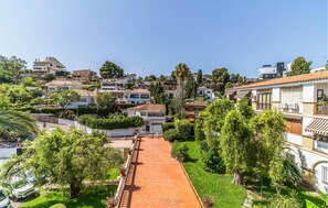 Ein Wohngebiet mit einem gepflasterten Weg, der durch einen Garten führt, umgeben von Häusern mit unterschiedlicher Architektur.
