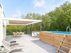 An outdoor patio with a pool, lounge chairs, and a covered seating area. - 3-bedroom apartment measuring 86 m², with a 70 m² rooftop terrace and a private pool (Saint-Raphaël)