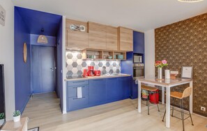 A compact kitchen with blue cabinets, a microwave, and a coffee maker. - Nice apartment in Lezardrieux with house sea view (Lezardrieux)