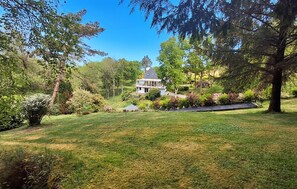 A house surrounded by a well-maintained lawn and various trees. - Gorgeous apartment in Plouégat-Moysan with sauna (Plouégat-Moysan)