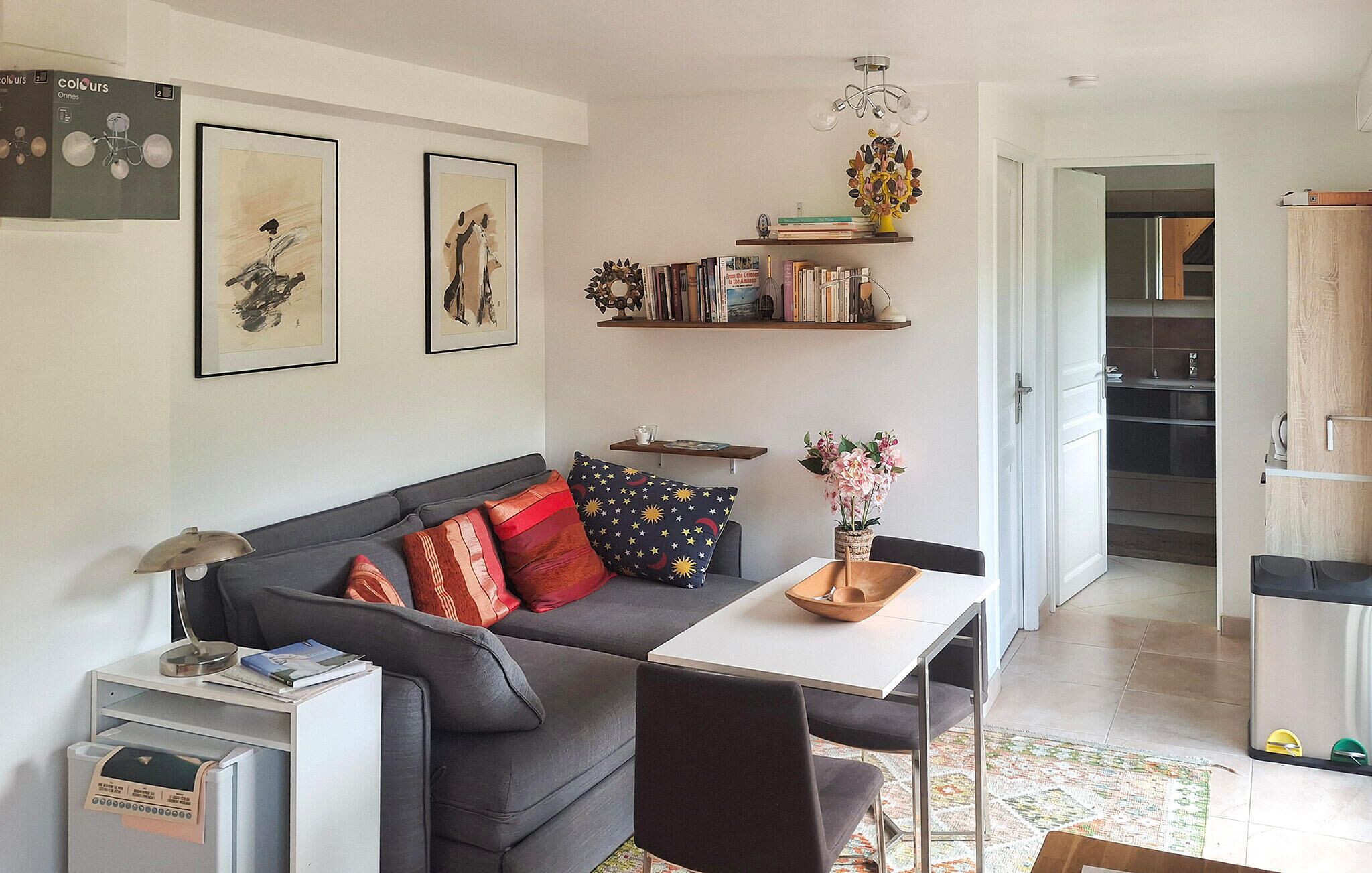 A living room with a sofa, a dining table, and a bookshelf.