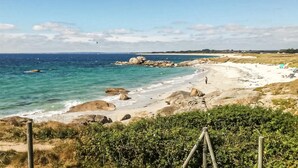 Une plage avec une eau claire, des rochers et une rive sablonneuse.