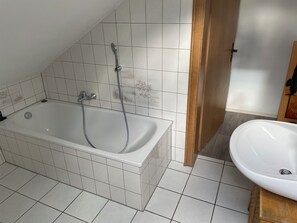 A bathroom with a bathtub, a shower, and a sink. - Accommodations in a Hiking Paradise (Neuleiningen)