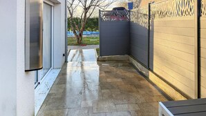 A narrow outdoor corridor with a tiled floor, a metal gate, and a wall with a decorative pattern. - Beautiful home in Fondettes with WiFi (Fondettes)