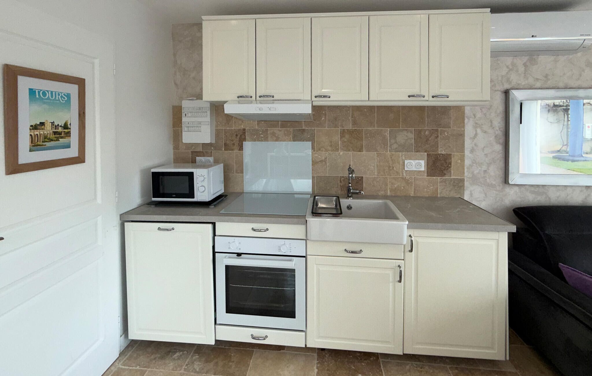 Una kitchenette compacta con microondas, horno, pileta y placares.