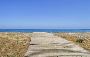 A wooden pathway leading to a beach with a clear blue sky. - Nice apartment in Ste Lucie De Moriani (Ste Lucie De Moriani)
