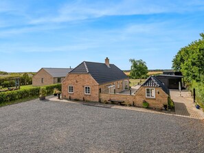 A residential property with a gravel driveway, brick houses, and a garden. - "Meindor" - 450m to the fjord by Interhome (Ulfborg)