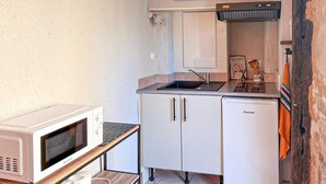 A compact kitchen with a microwave, a sink, and a Brandt refrigerator. - Beautiful apartment in Puy-L'Evêque (Puy-L'Evêque)