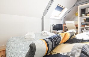 A room with a bed, a television, a desk, and a skylight. - Close to D-Day beaches (Isigny-sur-Mer)